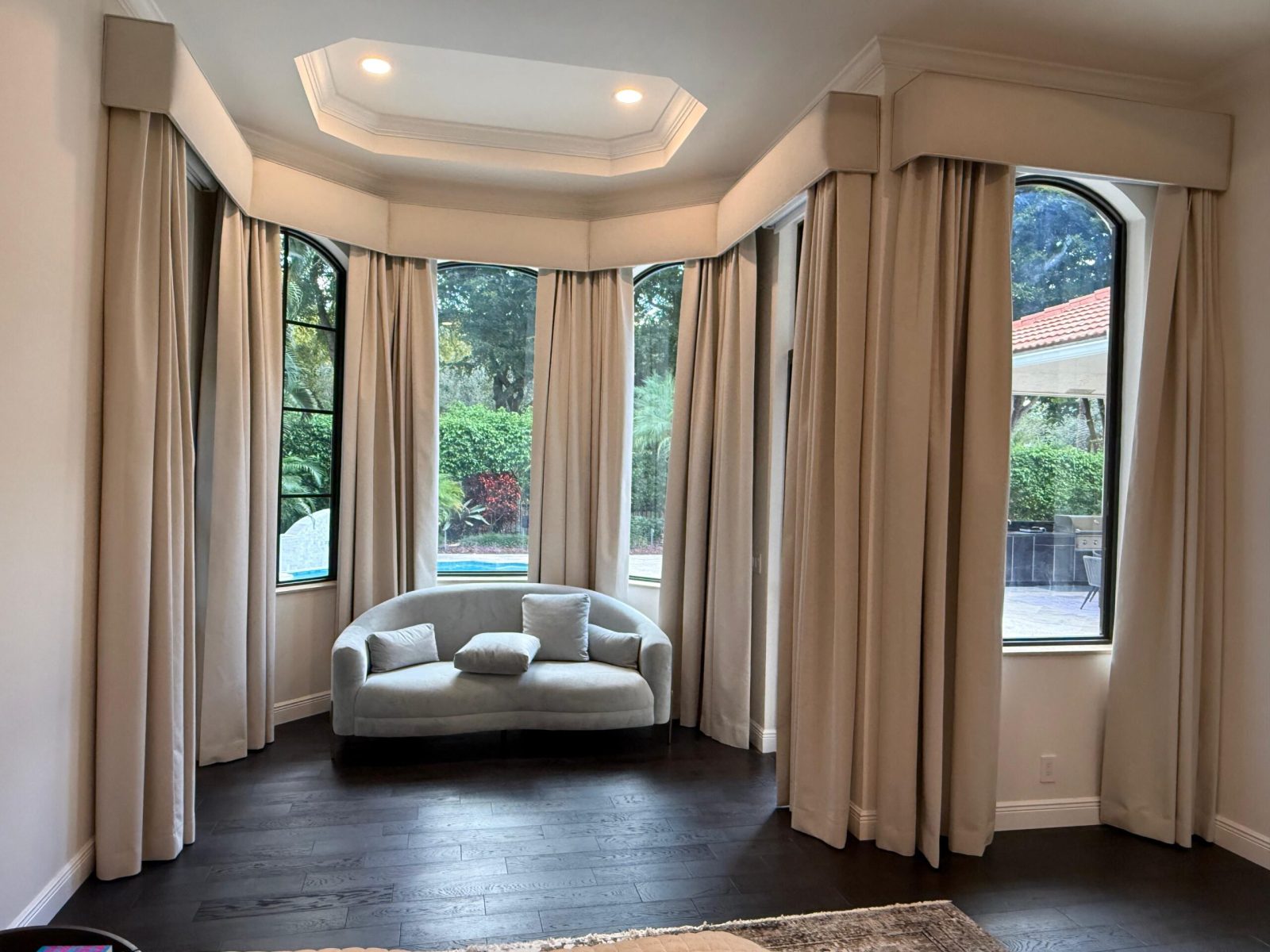 Floor to ceiling drapery with upholstered cornice boxes in a curved bay window