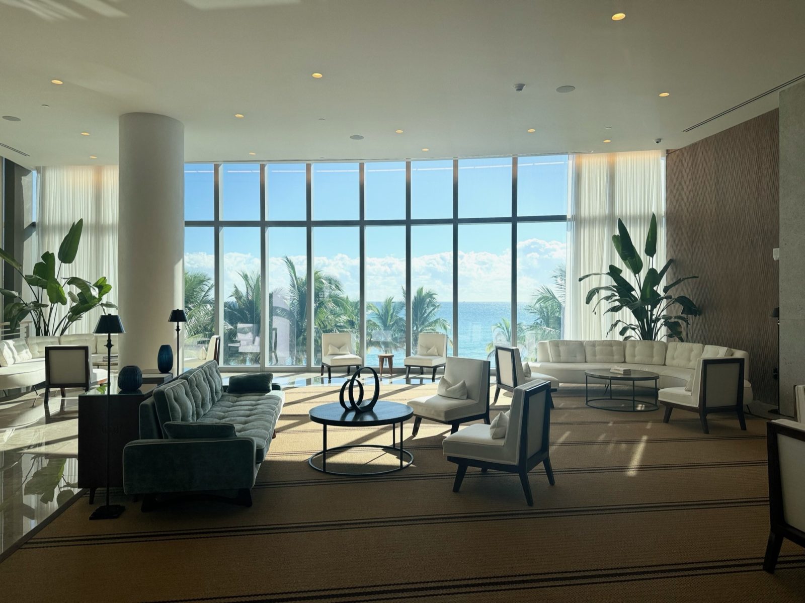 Sheer drapery panels across a wall of floor to ceiling oceanfront glass in a South Florida residence