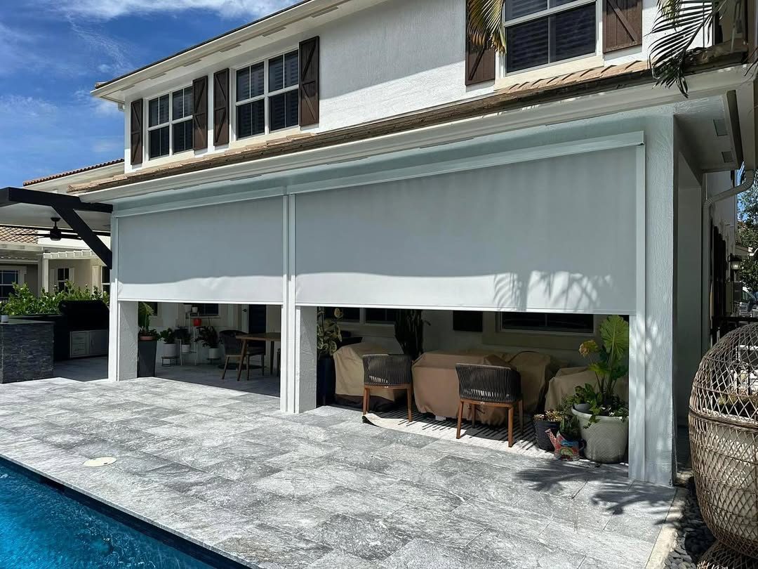 Large screens dropped across a poolside lanai, turning an exposed patio into a shaded outdoor room.